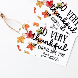 May include: Two white gift tags with a fall leaf pattern. The text on the tags reads "SO VERY thankful for clients like you!" and "Thank you for your referrals!"