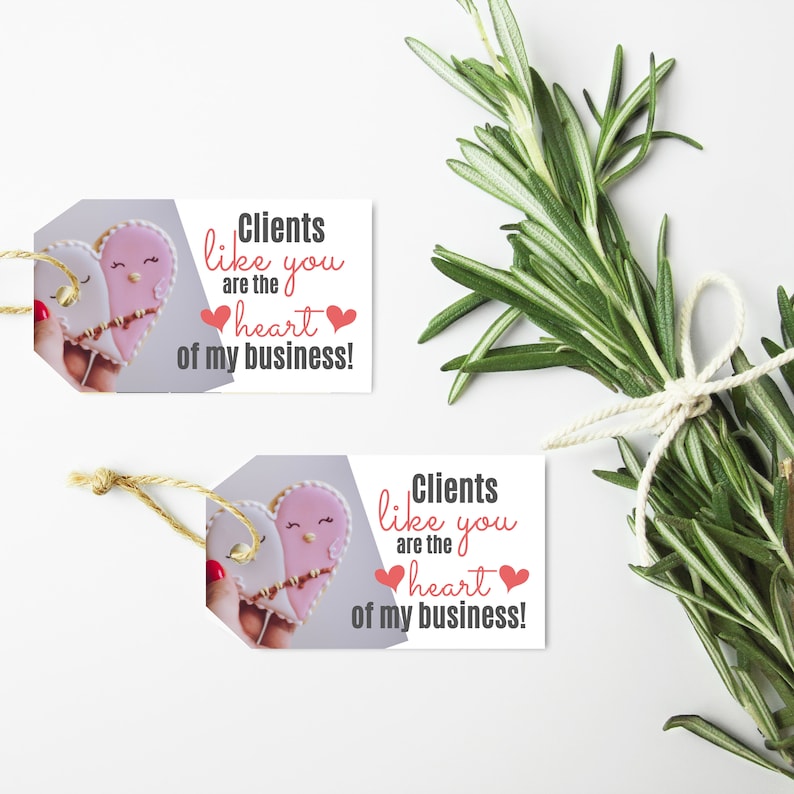 Puede incluir: Dos etiquetas de regalo con un dise&ntilde;o de galleta en forma de coraz&oacute;n y el texto "Clients like you are the heart of my business!" impreso en ellas.
