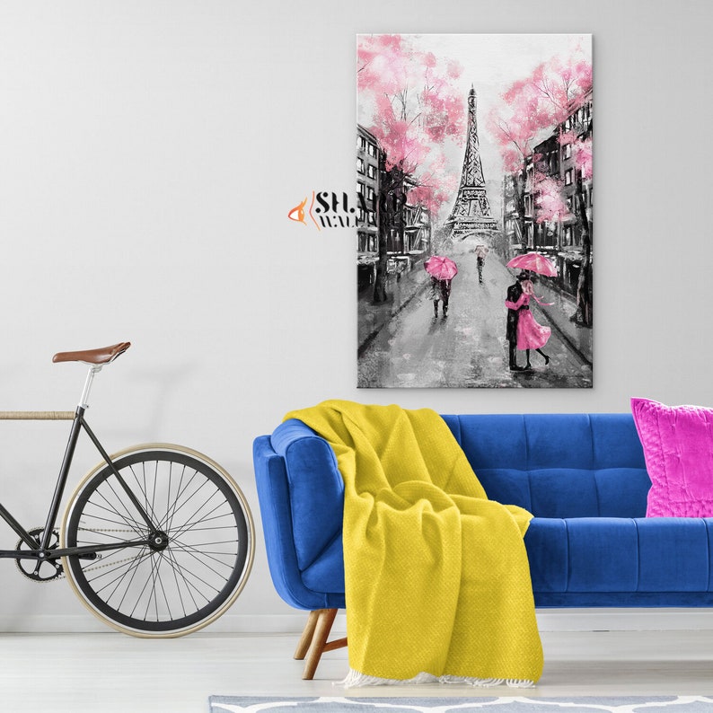 Puede incluir: Una pintura en blanco y negro de la Torre Eiffel en Par&iacute;s, Francia. La pintura presenta cerezos en flor rosa y parejas caminando bajo paraguas rosas.