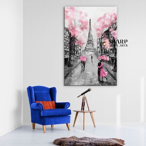 Puede incluir: Una pintura en blanco y negro de la Torre Eiffel en Par&iacute;s, Francia. La pintura presenta cerezos en flor rosa y una pareja bes&aacute;ndose bajo una sombrilla rosa. La pintura est&aacute; enmarcada y colgada en una pared blanca.