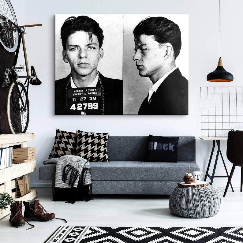 May include: Black and white mugshot style photo of a man with short dark hair. The photo is a vintage style print and has the text "Bergen County Sheriff's Office" and the number "42799" printed on it.