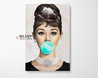 May include: A woman with a classic hairstyle and pearl necklace blows a blue bubble gum bubble. The background is a light beige color.