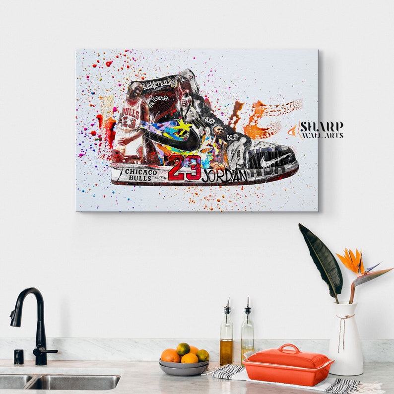 May include: A colorful abstract painting of a basketball shoe with a basketball player in the background. The shoe is a white and black Air Jordan with a red and black swoosh. The background is a white canvas with colorful paint splatters. The text "CHICAGO BULLS" and "23 JORDAN" is visible on the shoe.