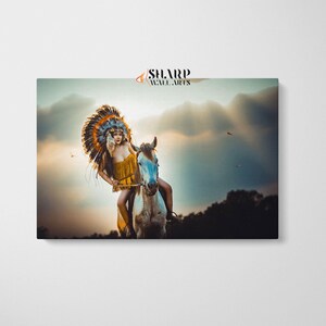 May include: A woman wearing a colorful headdress and a yellow fringe top rides a white horse against a cloudy sunset sky.
