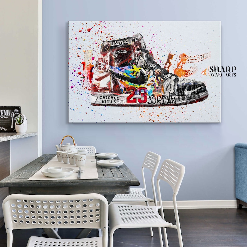 May include: A white canvas print with a colorful abstract design featuring a basketball shoe with the number 23 and the words "Chicago Bulls" and "Jordan". The design includes splashes of color and a basketball player in the background.