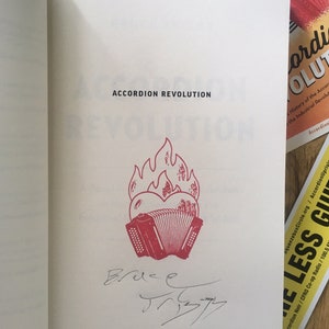 The signed opening page of my book with a flaming heart Accordion rubber stamped on it.