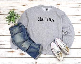May include: Gray sweatshirt with the text "tia life" and a small heart in black lettering.