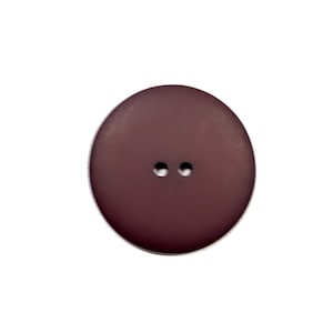 May include: A two-hole dark brown button.