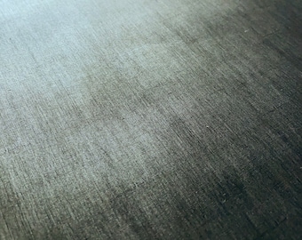May include: Close-up of a dark gray, textured surface with a subtle gradient. The surface has a linear pattern, creating a sense of depth and dimension. The overall effect is a blend of light and shadow.