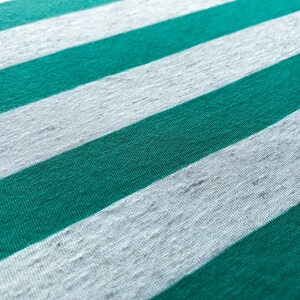 Puede incluir: Primer plano de una tela con rayas alternas de verde azulado y blanco.
