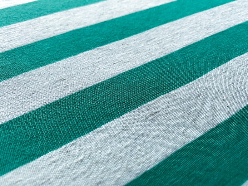 Puede incluir: Primer plano de una tela con rayas alternas de verde azulado y blanco.