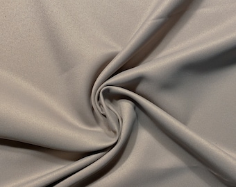 May include: A close-up of a light gray fabric with a subtle ribbed texture. The fabric is folded and draped, showcasing its soft and smooth feel.