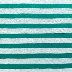 Puede incluir: Una tela rayada blanca y verde azulada con una superficie texturizada.