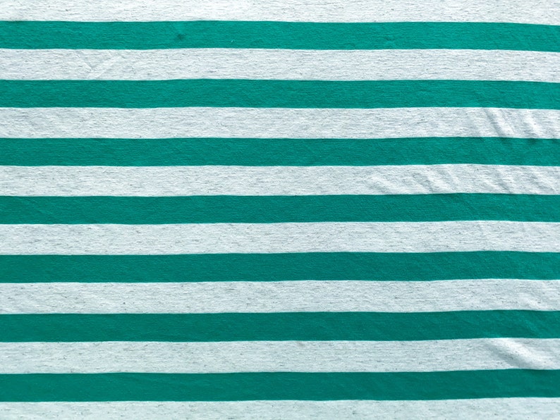 Puede incluir: Una tela rayada blanca y verde azulada con una superficie texturizada.