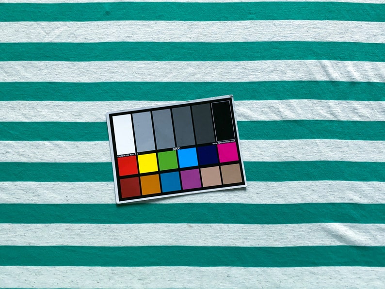 Puede incluir: Un primer plano de una muestra de tela a rayas de color turquesa y blanco con una tabla de colores para fotograf&iacute;a digital.