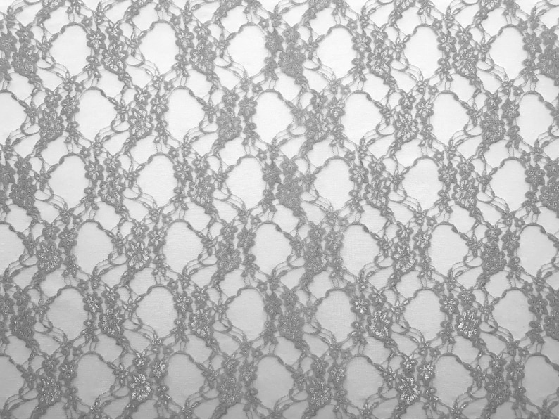 May include: A close-up of silver lace fabric with a delicate floral pattern. The lace is soft and sheer, with a subtle shimmer.