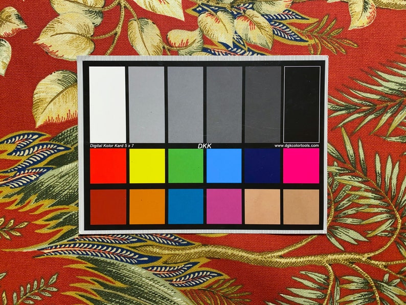 May include: A color chart with 24 color swatches, including white, black, red, yellow, green, blue, brown, orange, and pink. The chart is labeled "Digital Kolor Kord 5 x 7" and "DKK".
