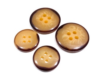 May include: Four brown and beige plastic buttons with four holes each. The buttons are arranged in a circle.