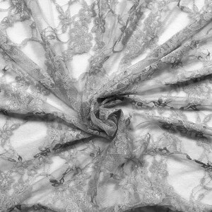 May include: Gray lace fabric with a delicate floral pattern. The fabric is soft and sheer, with a slightly textured surface.
