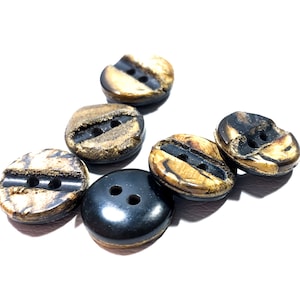 May include: Six buttons, five are brown with gold flecks and two holes, one is black with two holes.
