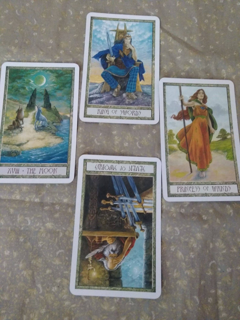 May include: Four tarot cards, featuring illustrations of a wolf howling at the moon, a king sitting on a throne, a woman holding a staff, and a man with swords. The cards are labeled "XVIII - The Moon", "King of Swords", "Princess of Wands", and "Seven of Swords".