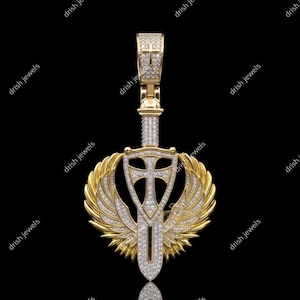 May include: A gold-toned pendant featuring a sword design with a cross and wings, encrusted with sparkling white stones. The pendant has a bail for a chain and is set against a black background.