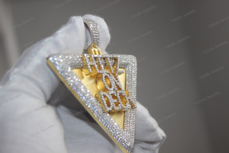 May include: A gold and silver triangle pendant with the words "Hype On Deck" set in diamonds.