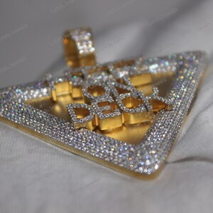 May include: A gold and silver triangle pendant with the words "Ice On Deck" set in diamonds.