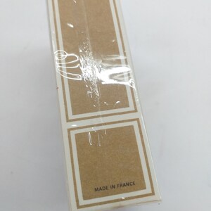 May include: A white cardboard box with a brown label that says "Made in France".