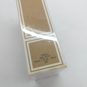 May include: A brown cardboard box with white text that reads "FIDJI Ref. 1210 Cont. 1 Fl.oz - 30 cc 85&deg;".