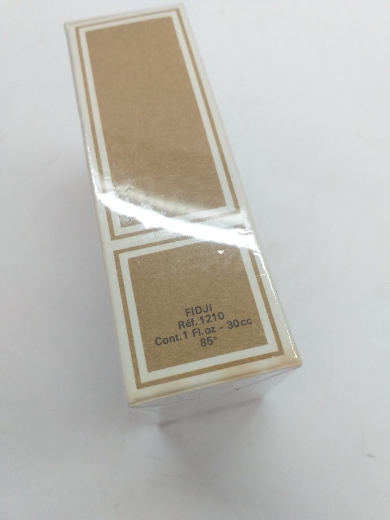 May include: A brown cardboard box with white text that reads "FIDJI Ref. 1210 Cont. 1 Fl.oz - 30 cc 85&deg;".