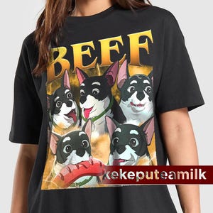 Puede incluir: Camiseta negra con un gráfico de cinco perros de dibujos animados con pelaje blanco y negro y orejas rosas. La palabra "BEEF" está impresa en letras doradas sobre los perros. El texto "kekeputeamilk" está impreso en blanco en la parte inferior.