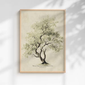 Puede incluir: Una impresión de arte mural enmarcada que presenta una ilustración detallada de un árbol con follaje verde apagado y un tronco oscuro sobre un fondo beige. El texto debajo del árbol dice: That ye, being rooted and grounded in love. EPHESIANS 3:17.