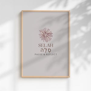 May include: A vertical rectangular wall art print in a light wood frame featuring a gray background. Centered is a dark brown line drawing of a flower above the text SELAH, the Hebrew word סלה, and the English phrase PAUSE & REFLECT in dark brown.