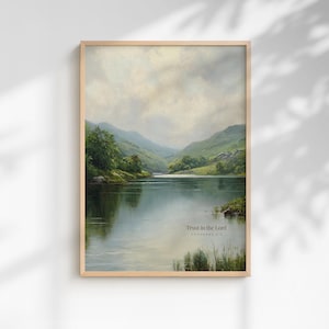 May include: A framed landscape print featuring a serene lake scene with mountains in the background. The artwork has a soft, muted color palette with shades of green, blue, and beige. Text at the bottom reads "Trust in the Lord PROVERBS 3:5".