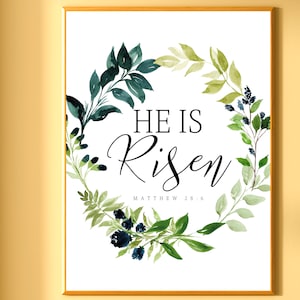 Puede incluir: Una impresión de arte imprimible blanca con una corona de acuarela verde y azul y el texto "Él ha resucitado" con la referencia bíblica "Mateo 28:6".