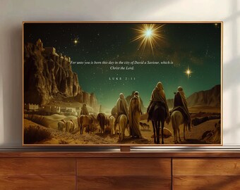 May include: A framed wall art print depicting a desert landscape at night with figures on horseback and camels under a bright star. The text reads: For unto you is born this day in the city of David a Saviour, which is Christ the Lord. LUKE 2:11.