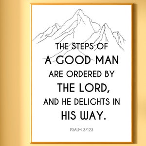 May include: A framed print with a gold border displays a black and white mountain illustration above a quote. The quote reads, "THE STEPS OF A GOOD MAN ARE ORDERED BY THE LORD, AND HE DELIGHTS IN HIS WAY." Psalm 37:23 is printed below.