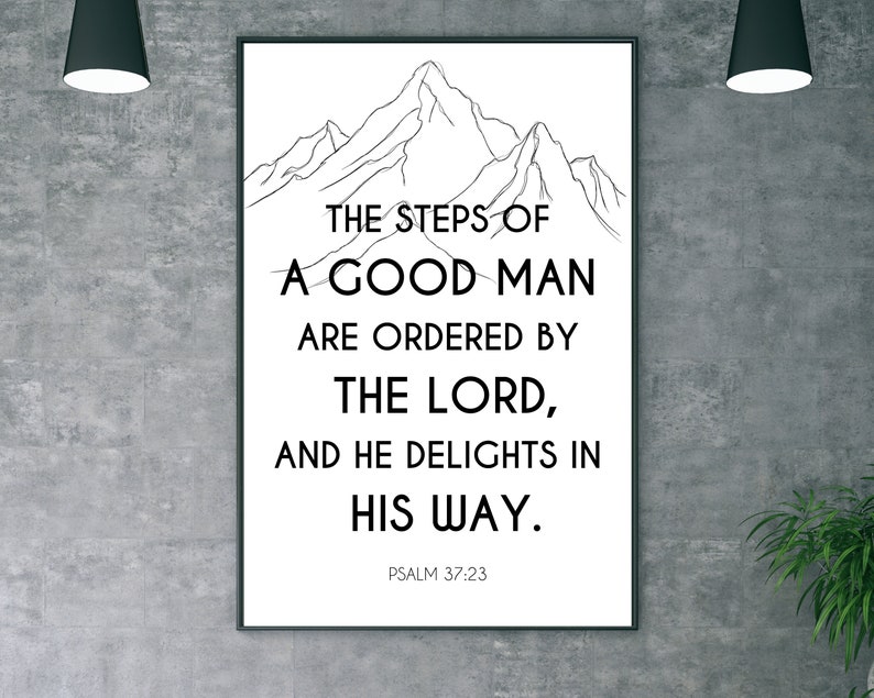 May include: Black framed wall art featuring the text "THE STEPS OF A GOOD MAN ARE ORDERED BY THE LORD, AND HE DELIGHTS IN HIS WAY." Psalm 37:23 is printed below the text. A mountain range is drawn above the text.