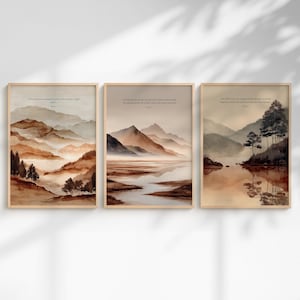以下が含まれることがあります： 茶色、ベージュ、クリーム色の水彩画風の風景が描かれた3枚の長方形のウォールアートプリント。各プリントには、重なり合う山脈、霧のかかった谷、木々が描かれており、上部中央に小さなテキストが印刷されています。