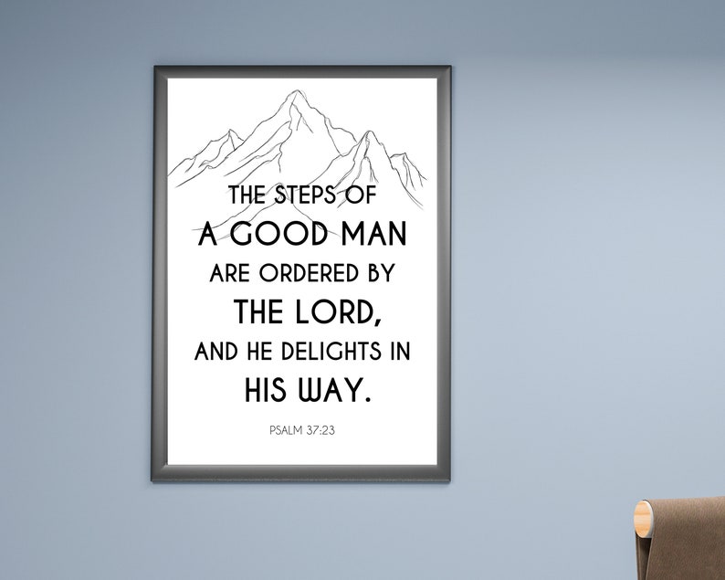 May include: A framed print with a black border, featuring a mountain illustration above the text: "THE STEPS OF A GOOD MAN ARE ORDERED BY THE LORD, AND HE DELIGHTS IN HIS WAY." The text "PSALM 37:23" is at the bottom.