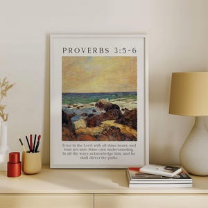 May include: A framed wall art print featuring a landscape painting of a rocky coastline with a yellow sky and blue ocean. The text PROVERBS 3:5-6 appears at the top, and the full verse is printed in black text at the bottom of the white frame.