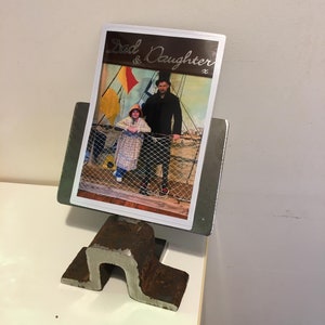 Op de afbeelding: Een foto van een vader en zijn dochter op een boot. De foto is in een metalen frame met de woorden "Dad & Daughter" erop.