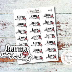 May include: A sheet of stickers with the phrase "Karma Solves Everything" in a stylish font, accompanied by a red lip graphic. The stickers are on a white background, with a wooden surface in the background.