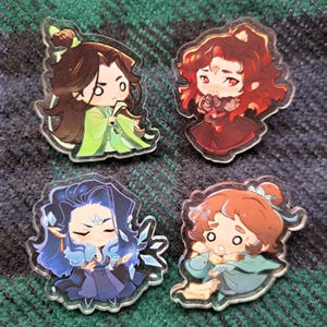 Puede incluir: Cuatro ilustraciones de personajes de estilo anime impresas en llaveros de acrílico transparente. Los personajes son todos hombres jóvenes con diferentes colores y estilos de cabello. Visten ropa colorida y tienen diferentes expresiones faciales.