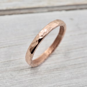 May include: A simple, hammered rose gold band ring.