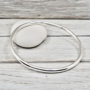 May include: A simple silver bangle bracelet, a classic and timeless piece of jewellery.