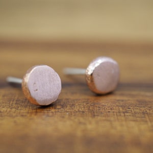 Puede incluir: Un par de pendientes de bot&oacute;n de oro rosa con un acabado martillado. Los pendientes son redondos y tienen una forma ligeramente irregular.