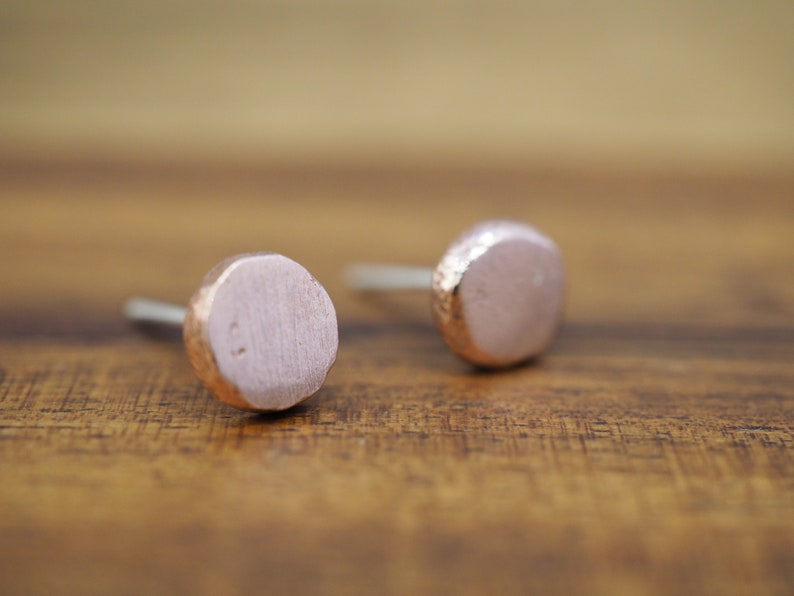Puede incluir: Un par de pendientes de bot&oacute;n de oro rosa con un acabado martillado. Los pendientes son redondos y tienen una forma ligeramente irregular.