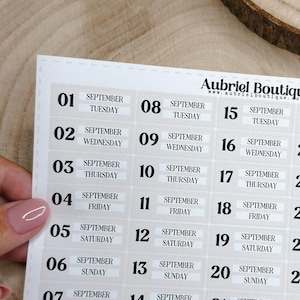 Può includere: Un foglio di adesivi rettangolare con un layout di calendario per settembre 2025 con etichette di data individuali da 01 a 30. Ogni etichetta include il giorno della settimana e il nome del mese. Il testo Aubriel Boutique è stampato in alto.